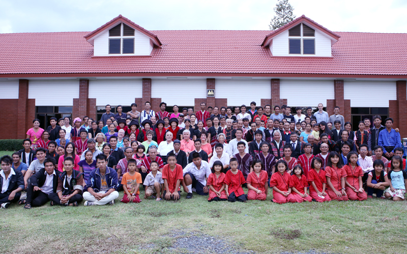 A large conference group in front of the main hall